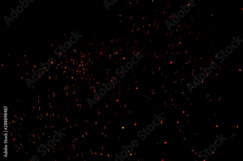 Burning red hot sparks fly from large fire in the night sky. Beautiful abstract background on the theme of fire, light and life. photo