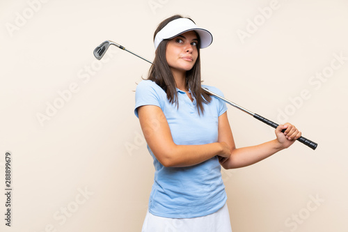 Young golfer woman over isolated background making doubts gesture while lifting the shoulders