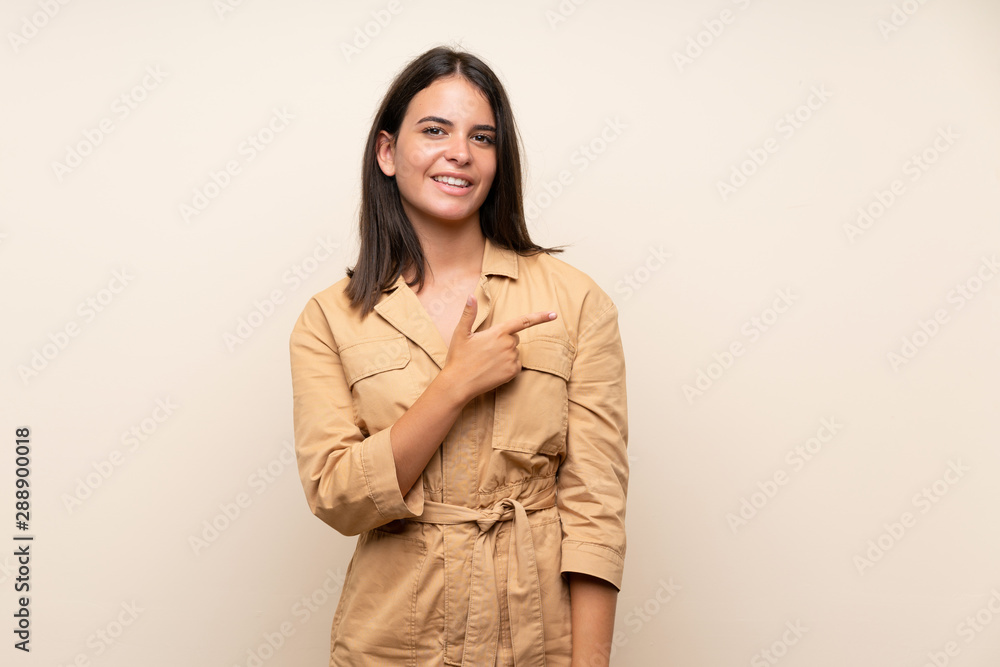 Young girl over isolated background pointing to the side to present a product Young girl over isolated background pointing to the side to present a product
