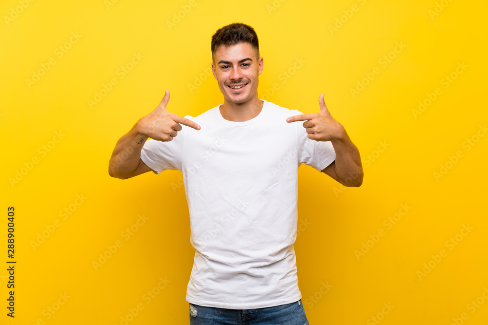 Young handsome man over isolated yellow background proud and self-satisfied Young handsome man over isolated yellow background proud and self-satisfied