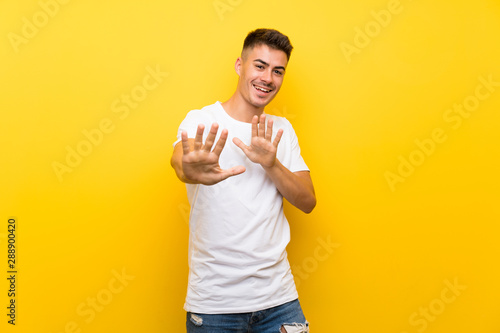 Young handsome man over isolated yellow background nervous stretching hands to the front © luismolinero