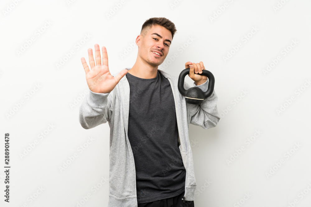 Sport man over isolated white wall saluting with hand with happy expression Sport man over isolated white wall saluting with hand with happy expression