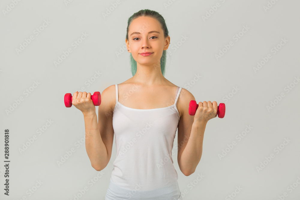 beautiful young woman in sportswear goes in for sports with dumbbells beautiful young woman in sportswear goes in for sports with dumbbells