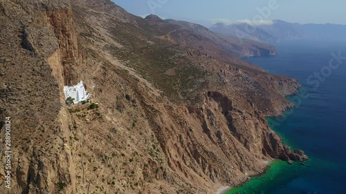 Aerial drone video of breathtaking whitewashed holy Monastery of Panagia Hozoviotissa built in a steep cliff overlooking the Aegean deep blue sea, Amorgos island, Cyclades, Greece photo