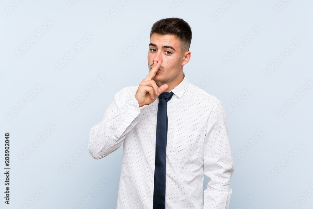 Handsome businessman over isolated blue background doing silence gesture Handsome businessman over isolated blue background doing silence gesture