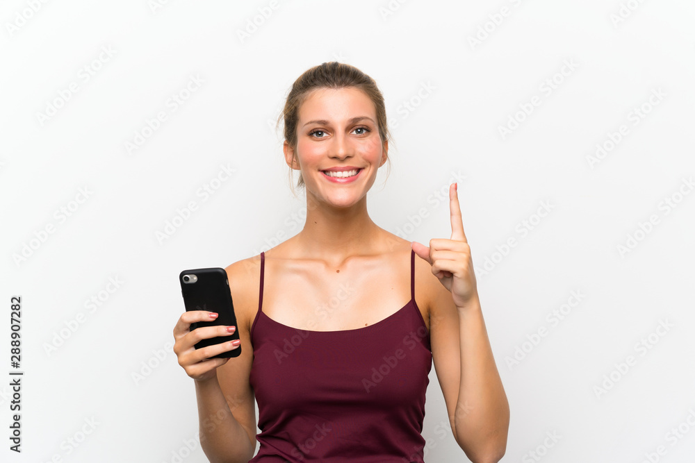 Naklejka premium Young blonde woman using mobile phone pointing with the index finger a great idea