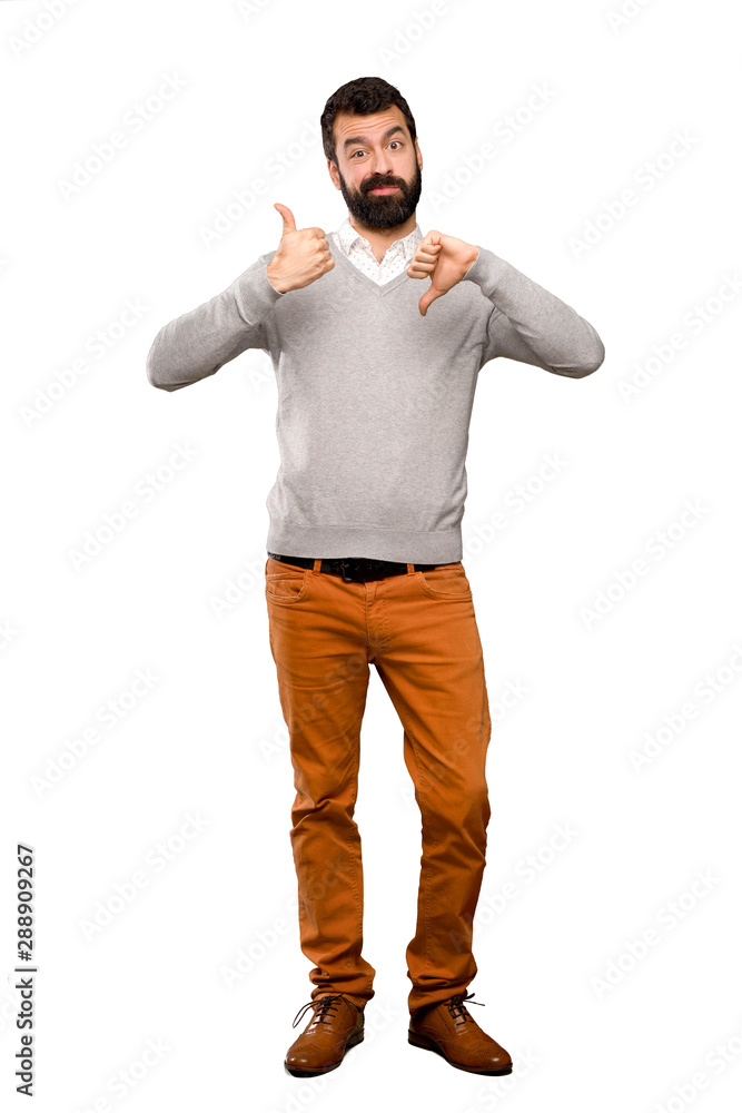 Handsome man making good-bad sign. Undecided between yes or not over isolated white background Handsome man making good-bad sign. Undecided between yes or not over isolated white background