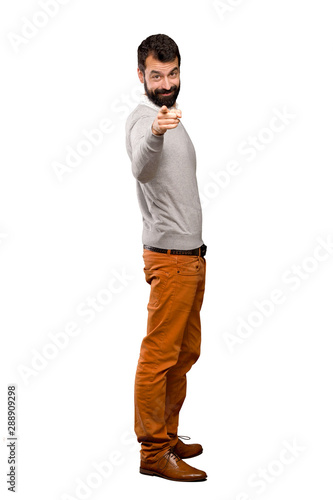 Handsome man points finger at you with a confident expression over isolated white background