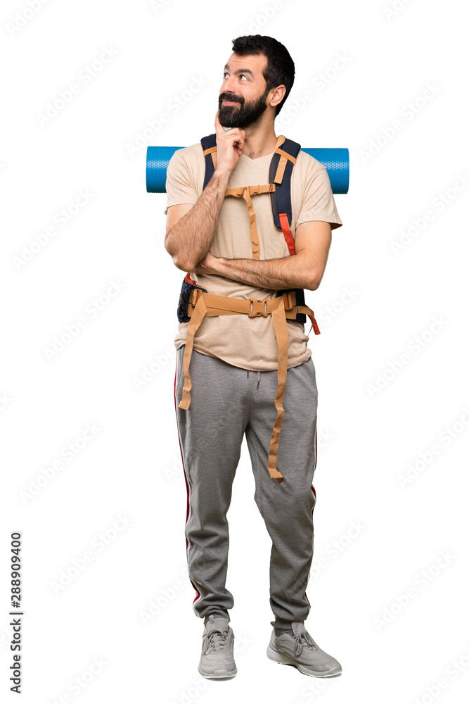 Hiker man thinking an idea while looking up over isolated white background Hiker man thinking an idea while looking up over isolated white background