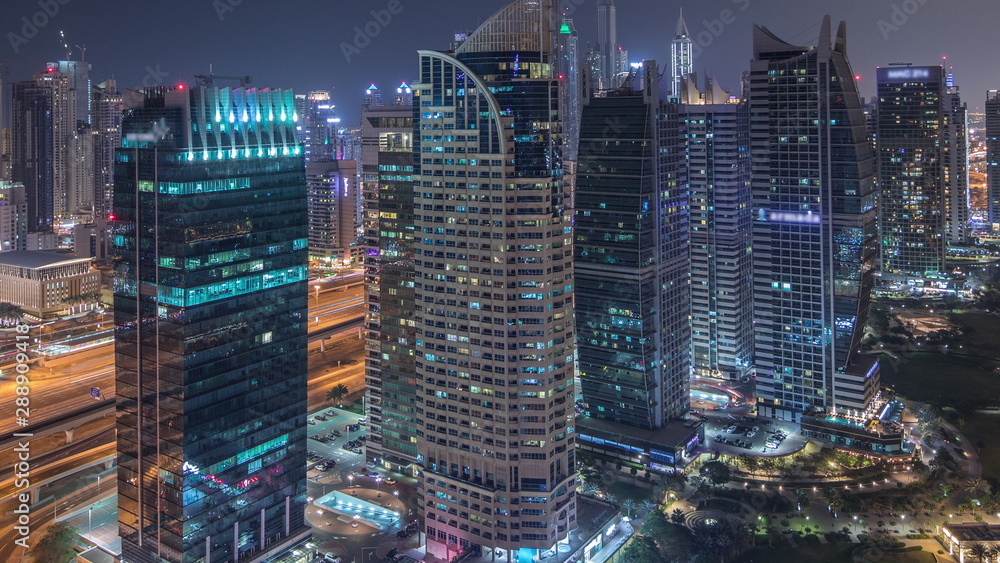 Obraz premium Jumeirah Lake Towers w dzielnicy mieszkalnej z lotu ptaka w nocy timelapse w pobliżu Dubai Marina
