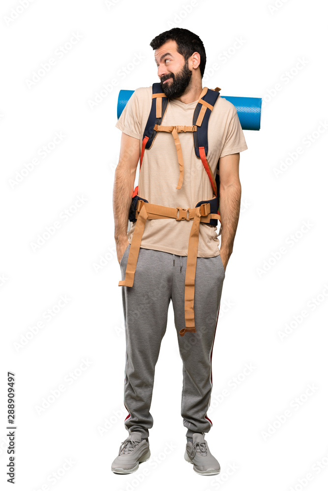 Hiker man making doubts gesture looking side over isolated white background Hiker man making doubts gesture looking side over isolated white background