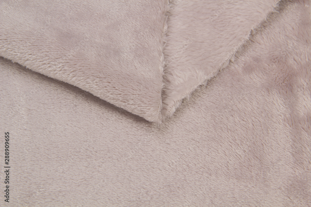 The blanket of furry fleece fabric. A background soft plush fleece material with a lot of relief folds The blanket of furry fleece fabric. A background soft plush fleece material with a lot of relief folds
