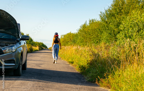 Beautiful young girl, in despair, she can not continue her journey because of the fact that her car broke down.