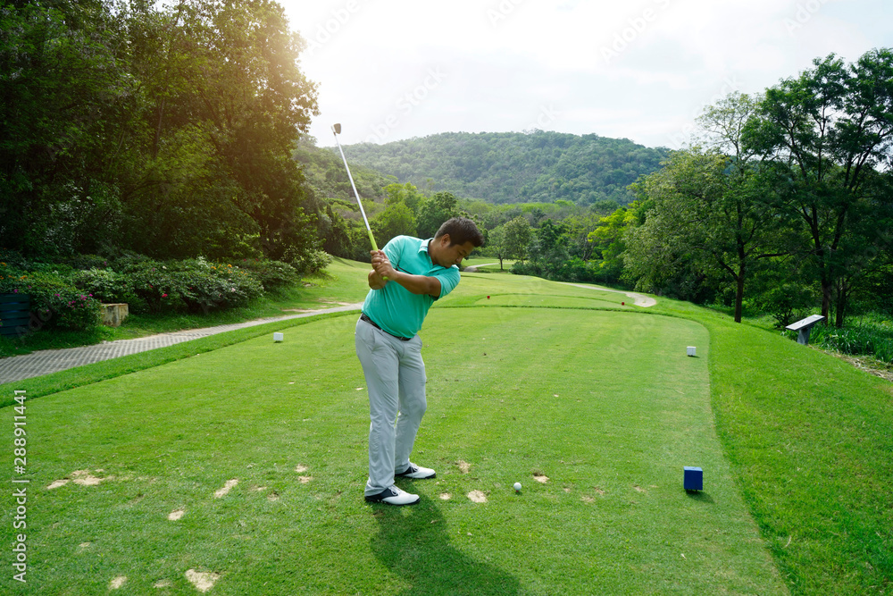 Blurred golfer playing golf in beautiful golf course in the evening golf course with sunshine in thailand Blurred golfer playing golf in beautiful golf course in the evening golf course with sunshine in thailand