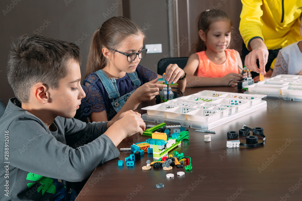 Kids creating robots with teacher. Early development, diy, innovation ...