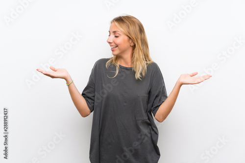 Blonde young woman over isolated white background holding copyspace with two hands