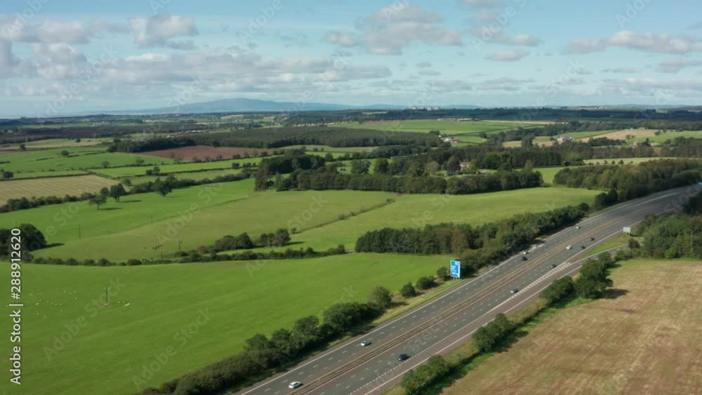 Motorway aerial view of cars with no traffic flowing nicely through the countryside in England Motorway aerial view of cars with no traffic flowing nicely through the countryside in England