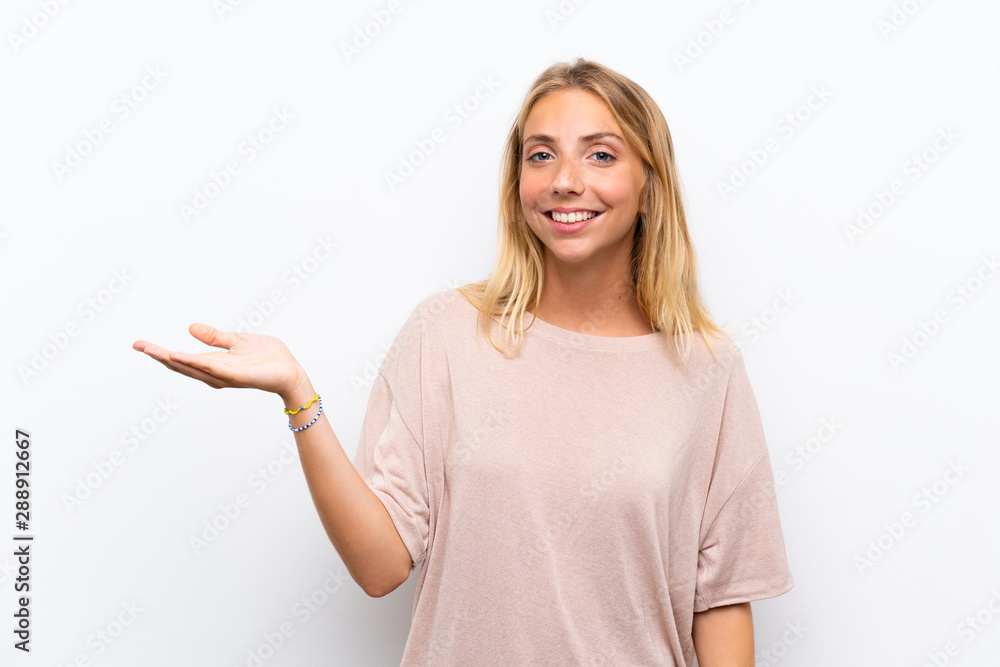 Blonde young woman over isolated white background holding copyspace imaginary on the palm Blonde young woman over isolated white background holding copyspace imaginary on the palm