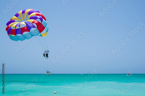 Colorful parasail wing flying over turquoise water of Sargasso Sea, Punta Cana, Dominican Republic
