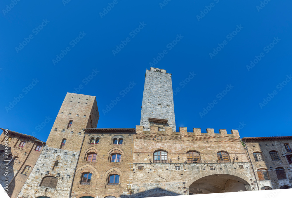 Old medeival square and towers in typical Tuscan town, popular tourist destination. Town also called  Medieval Manhattan for residential towers found therein.