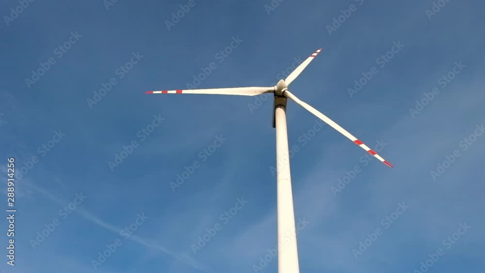 rotating blades of a windmill propeller on blue sky background. Wind power generation. Pure green energy. rotating blades of a windmill propeller on blue sky background. Wind power generation. Pure green energy.