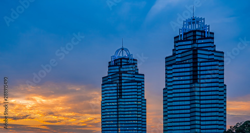 Quadro em tela Two blue glass office towers at sunrise