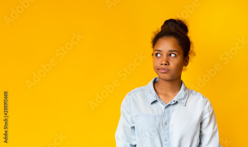 Annoyed african girl looking aside at free space