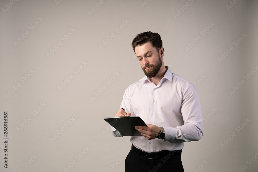 Middle age, 30-40s businessman signing official contract or filling business document with a pen, working in modern office with cup of coffee , close up. Middle age, 30-40s businessman signing official contract or filling business document with a pen, working in modern office with cup of coffee , close up.