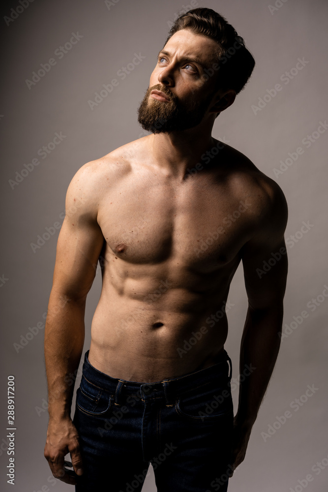 Photo of smiling mature man standing isolated over grey wall background naked. Looking in the left high corner. Photo of smiling mature man standing isolated over grey wall background naked. Looking in the left high corner.