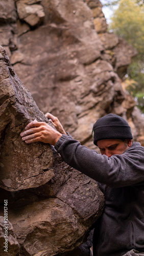 Half man face practising bouldering on rock © Elsa Fraga