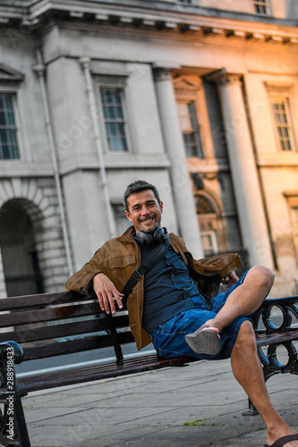 Photography Young smiling model man sitting doing tourism around Dublin City with casual style