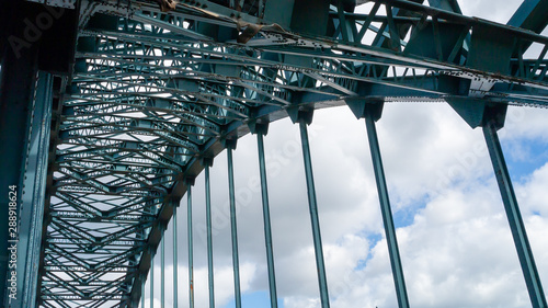 Internal image of the green painted steel structure featuring the arch of the Tyne Bridge in Newcastle upon Tyne taken against a contrasting summer sky.