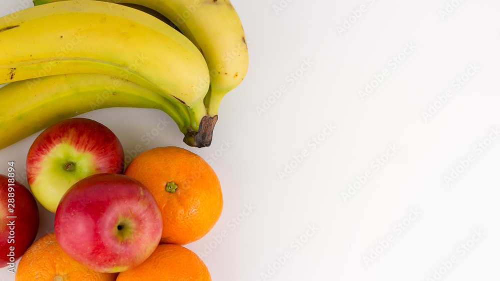 Overhead, closeup view of healthy fruit including Jazz apples, oranges and a bunch of ripe bananas featured on a white studio background. Overhead, closeup view of healthy fruit including Jazz apples, oranges and a bunch of ripe bananas featured on a white studio background.