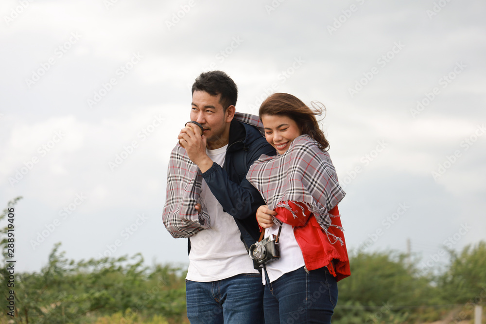 Fototapeta premium Asian couple drinking coffee travel in winter time mountain view background