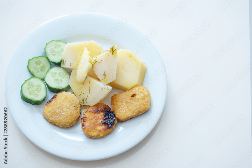 boy eating simple and cheap food for children - nuggets, cucumbers and potatoes boy eating simple and cheap food for children - nuggets, cucumbers and potatoes
