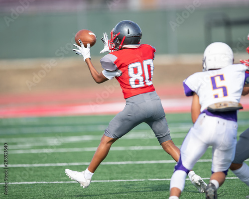 Young boys catching, running and throwing the ball during a football game