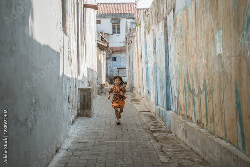 little asian traditional girl javanese running in the alleyway