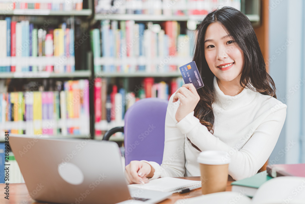 Beautiful women shopping online via laptops and credit cards Beautiful women shopping online via laptops and credit cards