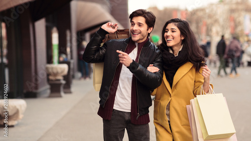 Photography Couple looking at fashion store's window, shopping together