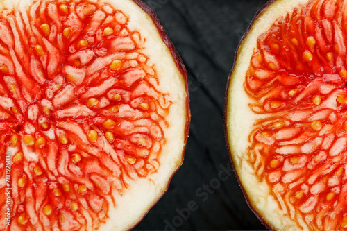 Figs are ripe. Closeup of sliced fig fruits in the form of a texture inscribed in a rectangle on a black texture background