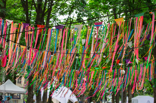 Festive color satin ribbons decorating the street. Wedding festive decoration, ribbons hanging on the trees in the park.