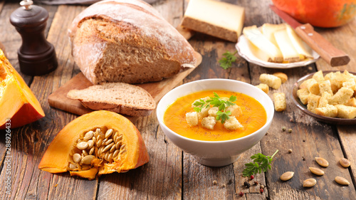 pumpkin soup in bowl with bread and cheese