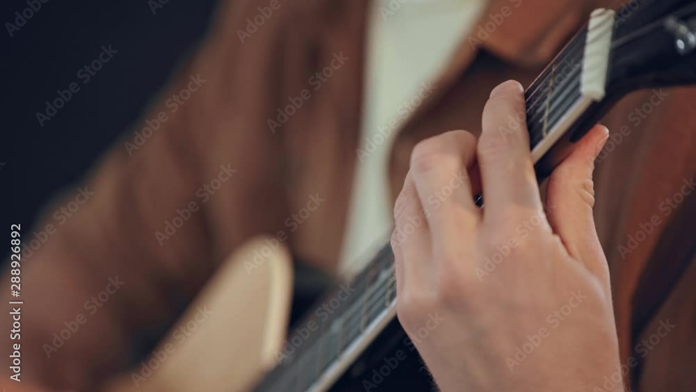 cropped view of man playing acoustic guitar at home