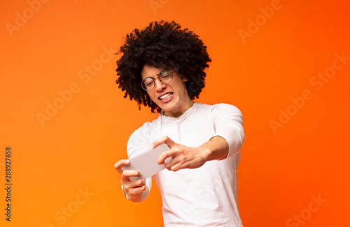 Stressed african man loosing in mobile video game photo