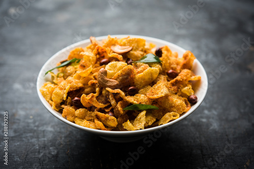 Cornflake Chivda or Corn Chiwda loaded with peanuts and Cashew. Served in a bowl. selective focus photo