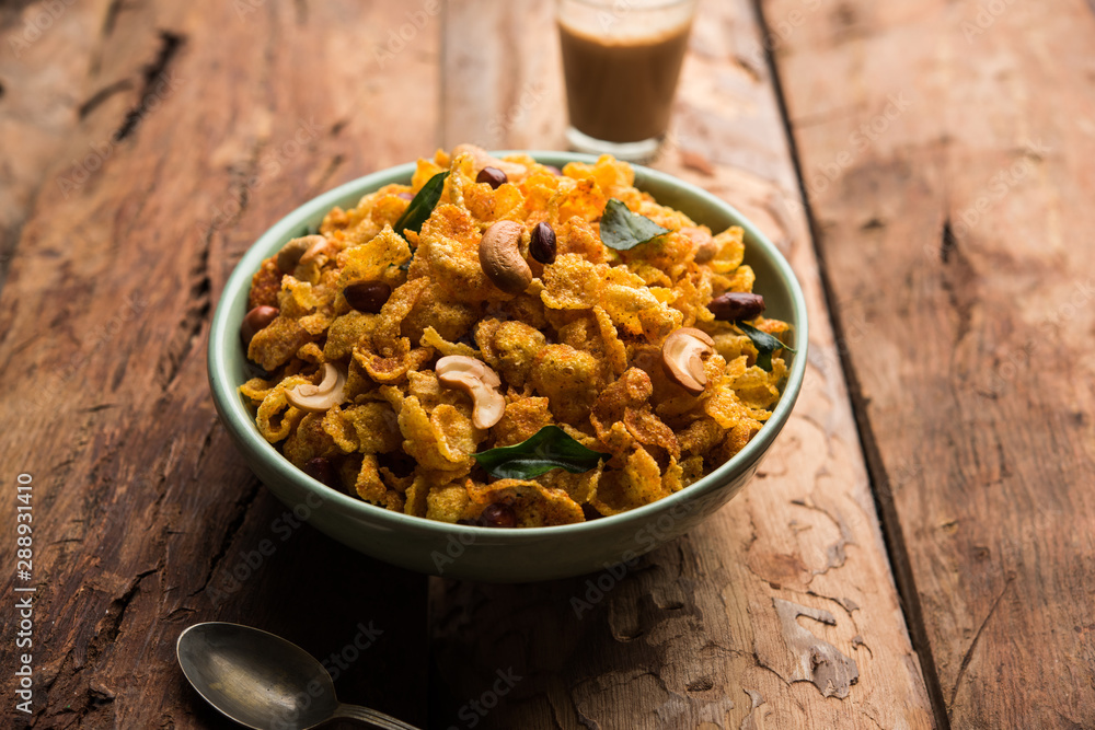Fototapeta premium Cornflake Chivda or Corn Chiwda loaded with peanuts and Cashew. Served in a bowl. selective focus