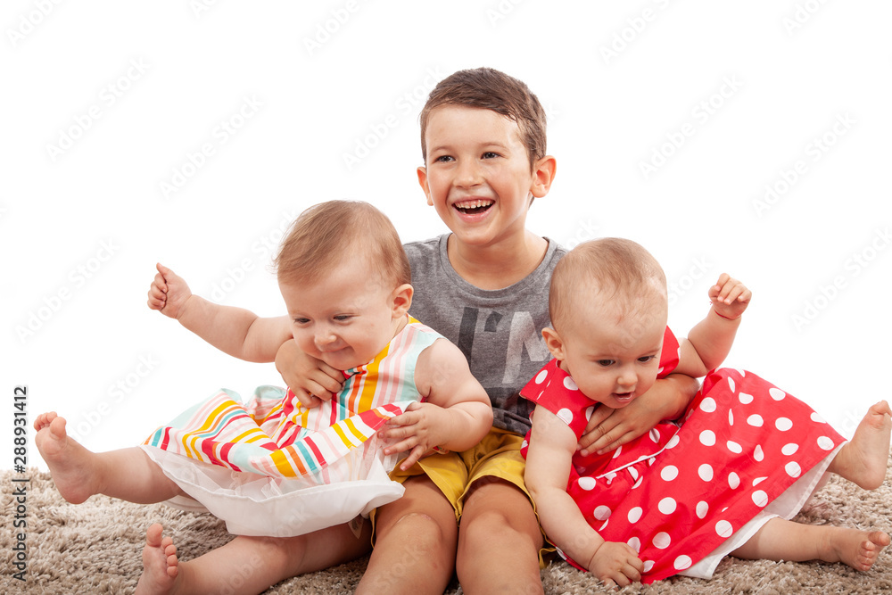 Brother embraced his little twin sisters, isolated on white. They are very happy with each other Brother embraced his little twin sisters, isolated on white. They are very happy with each other
