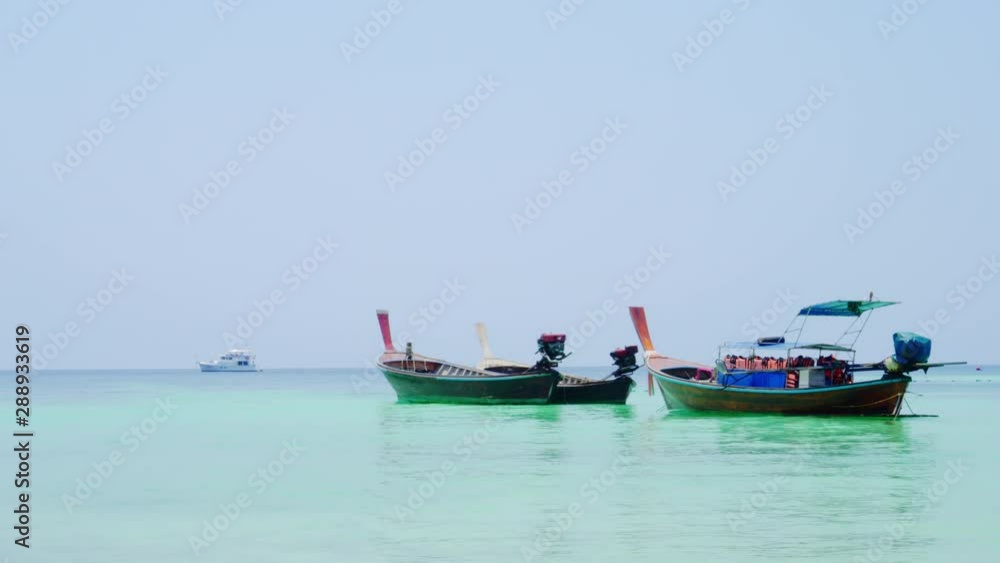 Long-tailed boat is floating on the emerald sea at Koh Lipe island in Satun, Thailand. Transportation for tourists. Long-tailed boat is floating on the emerald sea at Koh Lipe island in Satun, Thailand. Transportation for tourists.
