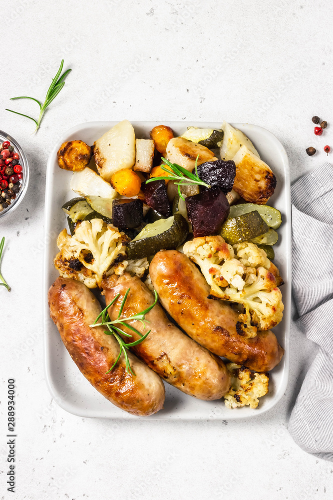 Grilled sausages with baked zucchini, potatoes, beets and cauliflower. Top view, space for text. Grilled sausages with baked zucchini, potatoes, beets and cauliflower. Top view, space for text.