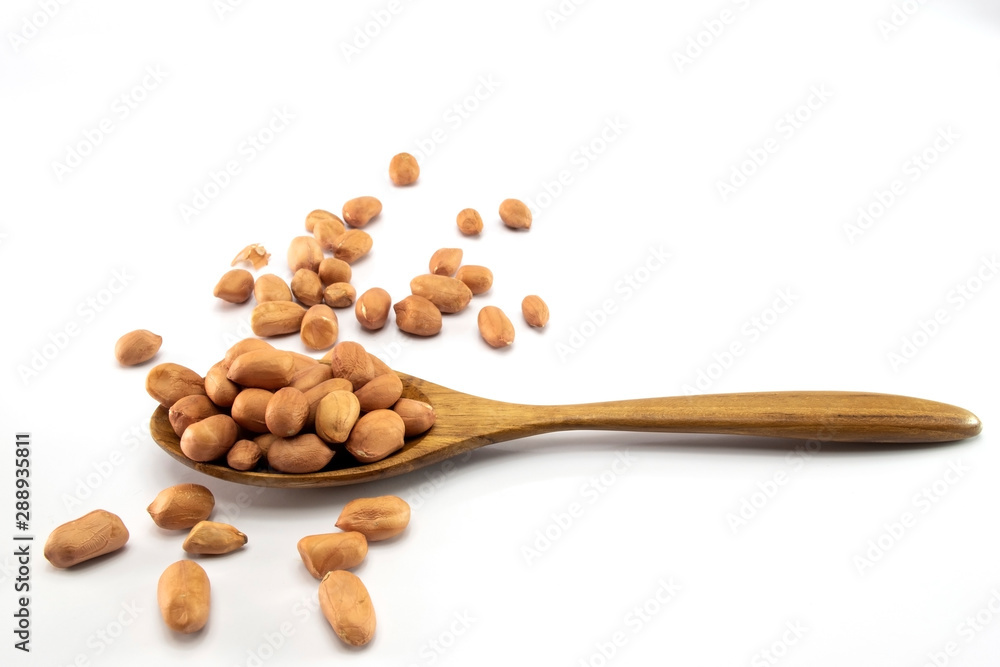 Peanuts in a wooden spoon And some are scattered isolated on a white background Peanuts in a wooden spoon And some are scattered isolated on a white background